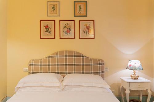 a bedroom with a bed and three pictures on the wall at Casa Uffizi XIII Century Tower House Boutique Hotel in Florence