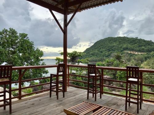 a deck with chairs and a view of a mountain at An Yen Resort in Phú Quốc