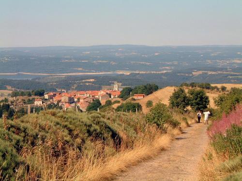 two people walking down a dirt path on a hill at Le Ponant in Pradelles