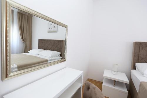 een slaapkamer met een spiegel en een bed bij APARTMANI GUTO in Podstrana