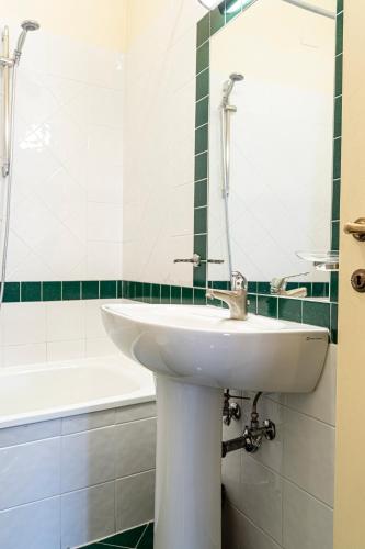 a bathroom with a sink and a mirror and a tub at Casa Uffizi XIII Century Tower House Boutique Hotel in Florence