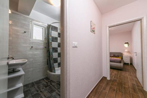 a bathroom with a sink and a toilet at Apartments La Flor in Brela