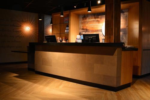 a restaurant with a counter with two laptops on it at Fletcher Strandhotel Haamstede in Burgh Haamstede