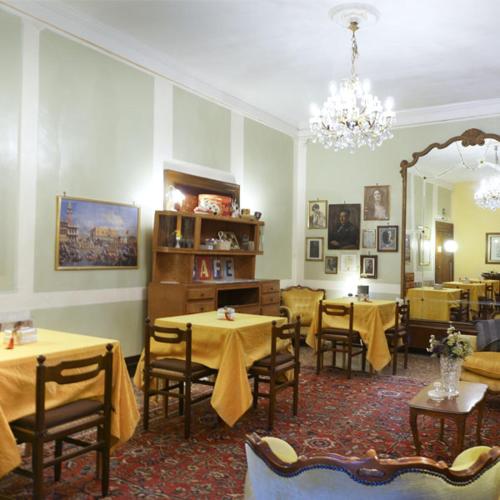 a dining room with two tables and a mirror at B&B Corte Campana in Venice