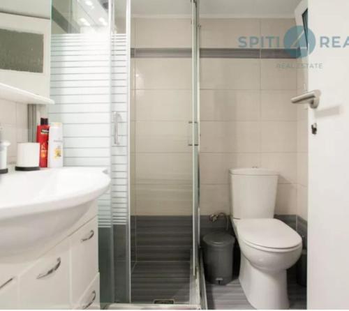 łazienka z toaletą i przeszklonym prysznicem w obiekcie Koukaki Apt 5 min walk to Acropolis w Atenach