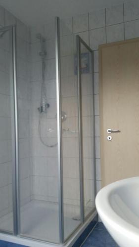 eine Glasdusche im Bad mit Waschbecken in der Unterkunft Ferienzimmer für Zwei am Strand in Zingst