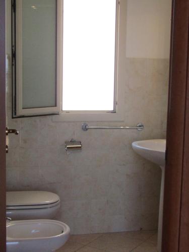 uma casa de banho com um WC, um lavatório e uma janela em Casa Vacanze Barone di Civico 24 em Scicli