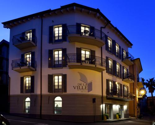 a tall yellow building with windows and balconies at Boutique Hotel de la Ville in Laigueglia