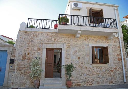 a stone house with a balcony and a door at Traditional House under Kazarma Fortress in Sitia in Sitia