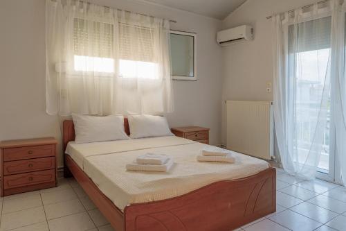 a bedroom with a bed with two towels on it at Nicole Fresh Apartments in Keramoti