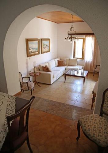a living room with a white couch and a table at Traditional House under Kazarma Fortress in Sitia in Sitia