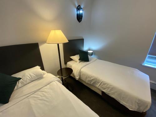 a hotel room with two beds and a lamp at No6 West Coates in Edinburgh