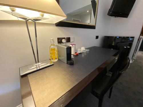 a kitchen counter with a bottle of alcohol and a lamp at No6 West Coates in Edinburgh