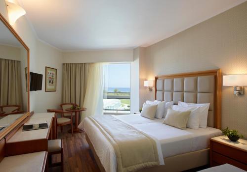 a hotel room with a large bed and a window at Apollo Beach in Faliraki