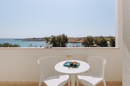 a table and chairs with a view of the ocean at Miramare Blue Stay in Torre Santa Sabina