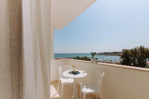 a balcony with a table and chairs and a view of the ocean at Miramare Blue Stay in Torre Santa Sabina