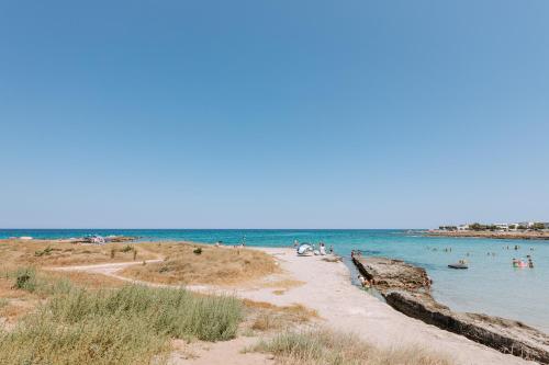 a beach with a bunch of people in the water at Miramare Blue Stay in Torre Santa Sabina