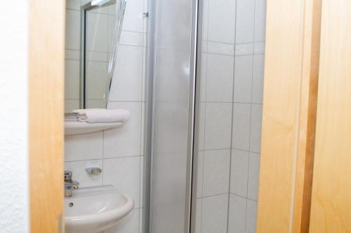 a bathroom with a shower and a sink at Stadthotel Marburg in Marburg an der Lahn