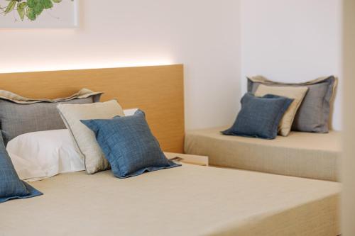a bedroom with two beds with blue pillows at Miramare Blue Stay in Torre Santa Sabina