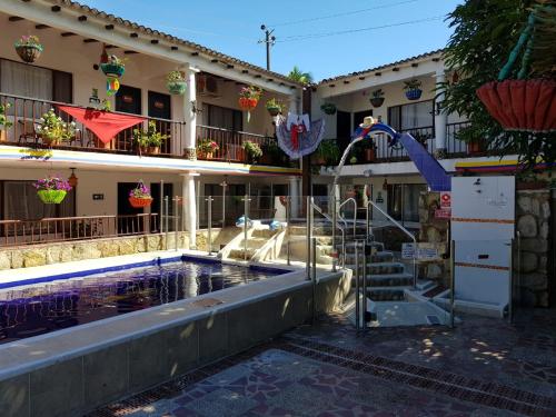 a hotel with a swimming pool in front of a building at Hotel Villa Maritza in Melgar