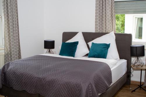 ein Schlafzimmer mit einem großen Bett mit blauen Kissen in der Unterkunft Stadthotel Marburg in Marburg an der Lahn