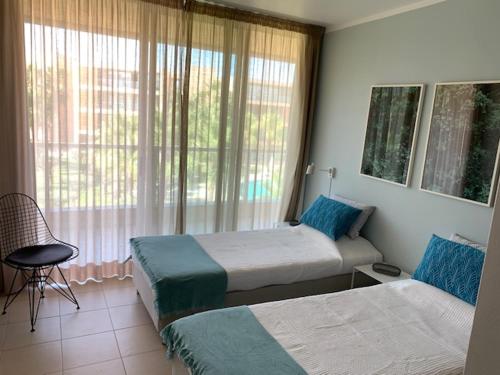 a hotel room with two beds and a window at Ambassador Salgados Beach Suites in Albufeira