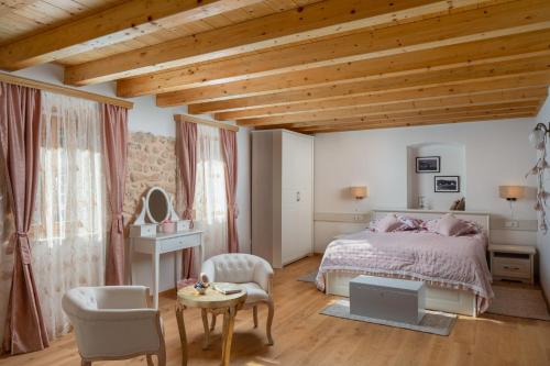 a bedroom with a bed and a table and chairs at Rustic luxury Villa Fulmin in Malo Grablje