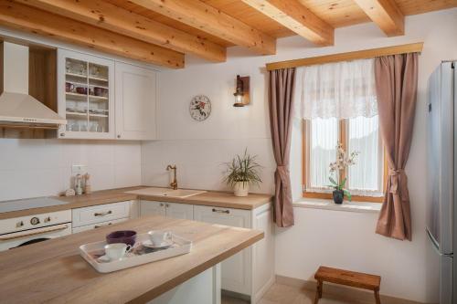 a kitchen with white appliances and a wooden ceiling at Rustic luxury Villa Fulmin in Malo Grablje