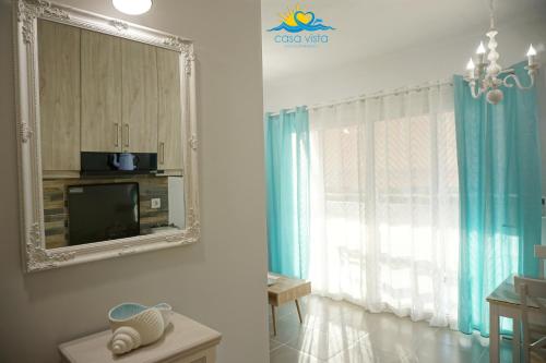 sala de estar con TV y ventana en Casa Vista Summer, en Karpathos