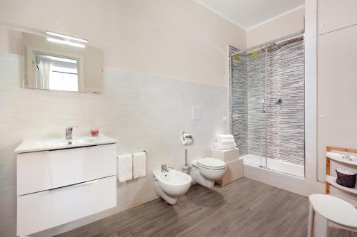 a white bathroom with a toilet and a sink at Emma luxury room in Sorrento