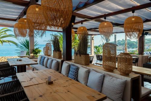 a restaurant with a table and chairs and a view of the ocean at Grande Real Santa Eulalia Resort & Hotel Spa in Albufeira