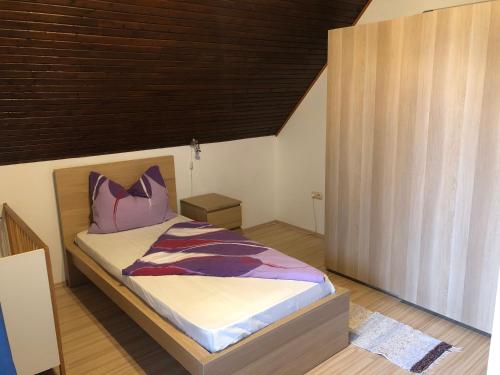 1 dormitorio con 1 cama con techo de madera en Valentin Vendégház, en Balatonlelle