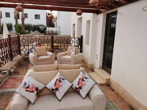 a couch sitting on a patio with pillows on it at Chic Apartment 2 in Sharm El Sheikh
