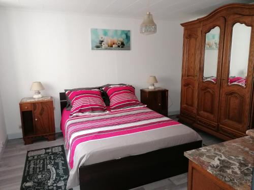 a bedroom with a bed with pink and white sheets at Gite la Tourbiere in Fellering