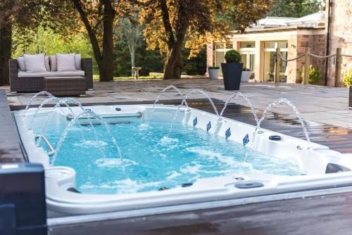 a pool with water fountain in a backyard at The Old Millhouse - Luxury Retreat with Sauna, Cold Plunge, Yoga & Swim SPA in Dalkeith