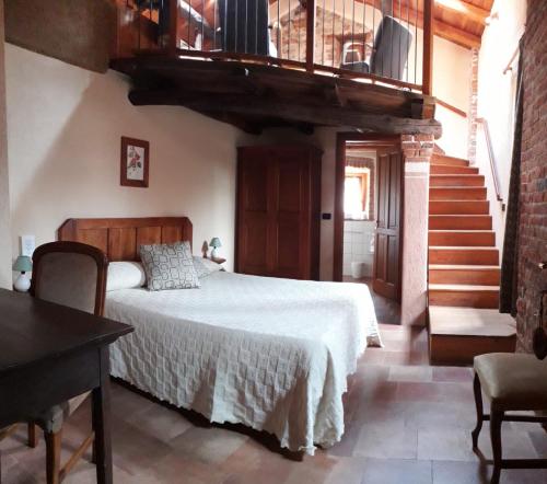 a bedroom with a bed and a wooden staircase at Locanda Dei Gelsi in Villar San Costanzo
