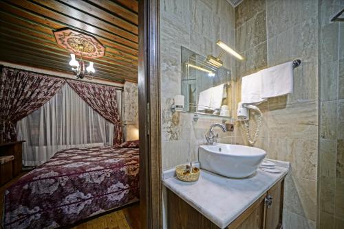 a bathroom with a sink and a bed at Alaturca House in Göreme