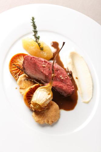 a plate of food with meat and other foods at Le Rosenmeer - Hotel Restaurant, au coeur de la route des vins d'Alsace in Rosheim