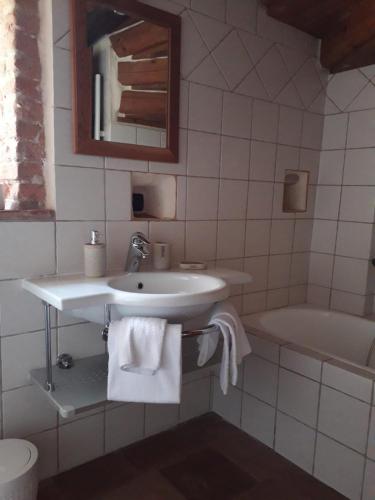 a white bathroom with a sink and a tub at Locanda Dei Gelsi in Villar San Costanzo