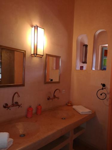 a bathroom with two sinks and two mirrors at Riad Ain Khadra in Taroudant