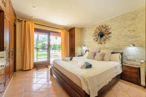 サンタ・エウラリア・デス・リウにあるCasa Beniのレンガの壁、大きなベッド付きのベッドルーム1室