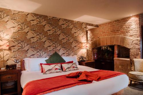 a bedroom with a bed and a brick wall at Newton Hall in Chathill