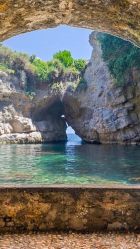 a view of the water through a rock cave at Hotel Spicy in Sorrento