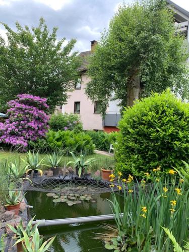 a garden with a pond in front of a house at Hotel Sonnenhof in Bad Wildbad
