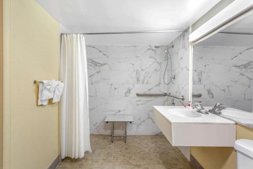 uma casa de banho com um lavatório e uma parede de mármore branco em Days Inn by Wyndham Hampton Near Coliseum Convention Center em Hampton