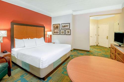 a hotel room with a bed and a flat screen tv at La Quinta by Wyndham Sherman in Sherman