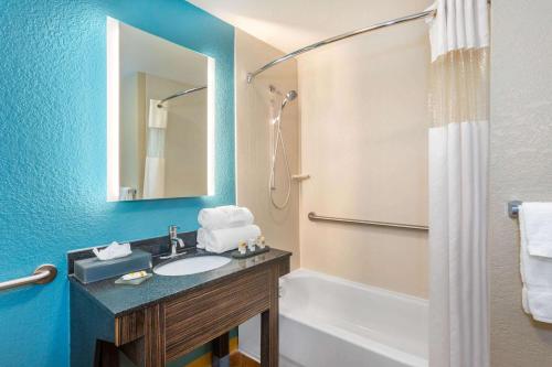 a bathroom with a sink and a tub and a mirror at La Quinta by Wyndham Sebring in Sebring