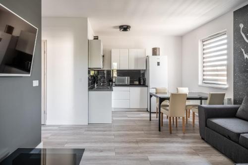 a living room with a table and a kitchen at RentPlanet - Apartamenty Na Grobli in Wrocław