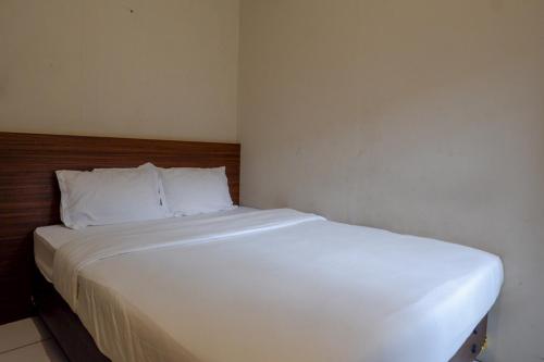 a large white bed in a small room at Kemang Place near Lippo Mall Kemang Mitra RedDoorz in Jakarta