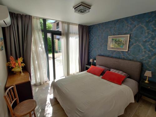 una camera da letto con un letto con cuscini rossi di Gîte Pavillon Arcadia a Vaison-la-Romaine